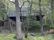 Charming raised house with a wooden deck, surrounded by lush trees and greenery at 1224 Island Creek Dr, Troy, NC 27371