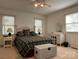 Cozy bedroom with a decorative headboard, soft carpeting, and natural light from two windows at 1224 Island Creek Dr, Troy, NC 27371