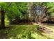 Spacious backyard with mature trees, a small fire pit, and a wooden fence at 12319 Cumberland Cove Dr, Charlotte, NC 28273