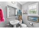 Cozy powder room featuring a pedestal sink, beach-themed decor, and a window with plantation shutters at 12319 Cumberland Cove Dr, Charlotte, NC 28273