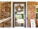 Close-up of a stylish front door with a decorative wreath and brick surround at 12319 Cumberland Cove Dr, Charlotte, NC 28273