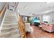 Inviting living room with hardwood floors, staircase, comfortable seating, and a large screen television at 12319 Cumberland Cove Dr, Charlotte, NC 28273