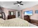 Spacious main bedroom with a ceiling fan, soft carpet, TV, and dark wood bedroom furniture at 12319 Cumberland Cove Dr, Charlotte, NC 28273