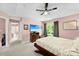 Light-filled main bedroom with tray ceiling, ceiling fan, carpeted floor, ensuite, and large window at 12319 Cumberland Cove Dr, Charlotte, NC 28273