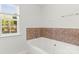 The bathroom features a luxurious soaking tub and a window for natural light at 13206 Meadowmere Rd, Huntersville, NC 28078