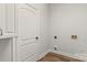 A compact and clean laundry room with modern flooring and neutral walls at 13206 Meadowmere Rd, Huntersville, NC 28078