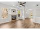 Open living room with a fireplace, ceiling fan, and hardwood flooring at 13206 Meadowmere Rd, Huntersville, NC 28078