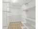 This walk-in closet features white shelving and beige carpeting at 13206 Meadowmere Rd, Huntersville, NC 28078