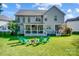 Spacious backyard with patio, green chairs, a fire pit and lush lawn perfect for outdoor activities at 15407 Saxon Trace Ct, Huntersville, NC 28078