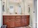 Bathroom vanity featuring double sinks, framed mirror, and wooden cabinets for ample storage at 15407 Saxon Trace Ct, Huntersville, NC 28078