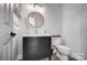 Powder room featuring modern vanity, round mirror, sconce lighting, and sleek fixtures at 15407 Saxon Trace Ct, Huntersville, NC 28078