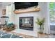 Cozy fireplace featuring decorative tiles, a wooden mantel, and a window with natural light is a focal point at 15407 Saxon Trace Ct, Huntersville, NC 28078