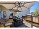 Private backyard patio features modern outdoor seating, overhead umbrella and built-in grill perfect for entertaining at 15613 Troubadour Ln, Huntersville, NC 28078