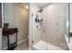 Modern glass-enclosed shower with neutral tile, sleek fixtures, and an adjacent toilet, creating a clean and functional bathroom space at 15613 Troubadour Ln, Huntersville, NC 28078