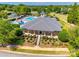 Beautifully landscaped clubhouse with community pool and splashpad, surrounded by lush greenery and playground at 15613 Troubadour Ln, Huntersville, NC 28078