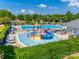 Aerial view of the community pool showcasing the play area, large pool, lounge chairs, and mature trees at 15613 Troubadour Ln, Huntersville, NC 28078