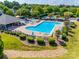 Aerial view of the community pool showcasing the play area, large pool, lounge chairs, and mature trees at 15613 Troubadour Ln, Huntersville, NC 28078