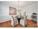 Cozy dining room featuring a round glass table, elegant chandelier, and decorative artwork at 15613 Troubadour Ln, Huntersville, NC 28078
