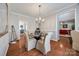 Elegant dining area with glass table, upholstered chairs, and access to other living spaces at 15613 Troubadour Ln, Huntersville, NC 28078