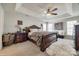 Luxurious main bedroom with tray ceiling, a large ornate bed, plush carpet and natural light, creating a serene sanctuary at 15613 Troubadour Ln, Huntersville, NC 28078