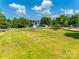 Community recreation area featuring a large grassy field and a playground under a bright blue summer sky at 15613 Troubadour Ln, Huntersville, NC 28078
