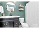 Charming bathroom showcasing a vanity, round mirror, and decorated shower curtain at 17546 Westmill Ln, Charlotte, NC 28277