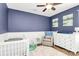 Stylish blue bedroom with a crib, dresser and seating area for baby and parents at 17546 Westmill Ln, Charlotte, NC 28277