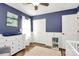 Comfortable blue bedroom with hardwood floors, white trim, and natural light at 17546 Westmill Ln, Charlotte, NC 28277