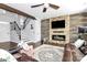 Spacious living room featuring a stone fireplace, wood accent wall, ceiling fan, and comfortable leather seating at 17546 Westmill Ln, Charlotte, NC 28277
