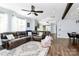 Open-concept living space showcasing a leather couch, hardwood floors, and seamless flow to the kitchen and dining areas at 17546 Westmill Ln, Charlotte, NC 28277