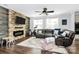 Comfortable living room with a fireplace, ceiling fan, and large windows providing natural light at 17546 Westmill Ln, Charlotte, NC 28277