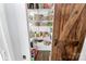 Organized walk-in pantry with white shelves and rustic wood door provides ample storage at 17546 Westmill Ln, Charlotte, NC 28277