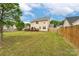 Large backyard with wooden fence, lush lawn, mature trees, and a back deck providing ample privacy at 225 Carrie Ct, Concord, NC 28027