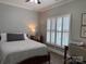 Comfortable bedroom with a bed, desk, and natural light from the window with plantation shutters at 227 Crystal Springs Ln, Shelby, NC 28150