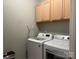 Functional laundry room with modern washer and dryer and wood cabinets for storing supplies at 227 Crystal Springs Ln, Shelby, NC 28150