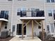 A view of the back of the home, featuring a small deck overlooking a concrete backyard at 2315 Doby Creek Ln # 77, Charlotte, NC 28262