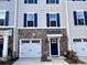 Charming townhome featuring stone accents, a one-car garage, and blue shutters on a sunny day at 2315 Doby Creek Ln # 77, Charlotte, NC 28262