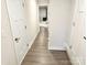 Inviting hallway featuring laminate floors, neutral walls, and white doors leading to different areas of the home at 2315 Doby Creek Ln # 77, Charlotte, NC 28262