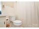 Compact bathroom includes a toilet and shower with a simple curtain at 2429 Sugar Mill Rd, Charlotte, NC 28210