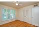 Bright bedroom with hardwood floors, large windows, a ceiling fan, and closet with doors at 2429 Sugar Mill Rd, Charlotte, NC 28210