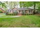 Charming brick home with manicured front lawn and mature landscaping creating excellent curb appeal at 2429 Sugar Mill Rd, Charlotte, NC 28210