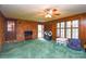 Living room with paneled walls, brick accent wall, multiple windows, and various furniture items at 2429 Sugar Mill Rd, Charlotte, NC 28210