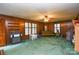 Living room with paneled walls, ceiling fan, multiple windows, and an eclectic mix of furniture at 2429 Sugar Mill Rd, Charlotte, NC 28210