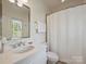 Elegant bathroom features a modern vanity, toilet, and shower with a white curtain and bright natural light at 2616 Colton Dr, Charlotte, NC 28211