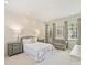 Bright bedroom with neutral decor, including a queen-sized bed, bedside tables, and sitting area at 2616 Colton Dr, Charlotte, NC 28211