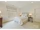 Bright bedroom featuring a cozy bed with patterned headboard and soft, neutral decor with natural light at 2616 Colton Dr, Charlotte, NC 28211