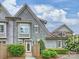Charming two-story townhome with grey siding, manicured landscaping, and a brick pathway leading to the front door at 2616 Colton Dr, Charlotte, NC 28211