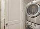 Efficient laundry area showcasing a stacked washer and dryer with modern appliances, and a door to the side at 2616 Colton Dr, Charlotte, NC 28211
