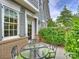Private patio with a glass-top table and four chairs, enclosed by a brick wall and shrubbery at 2616 Colton Dr, Charlotte, NC 28211