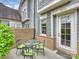Private patio with a glass-top table and four chairs, enclosed by a brick wall for outdoor entertaining at 2616 Colton Dr, Charlotte, NC 28211